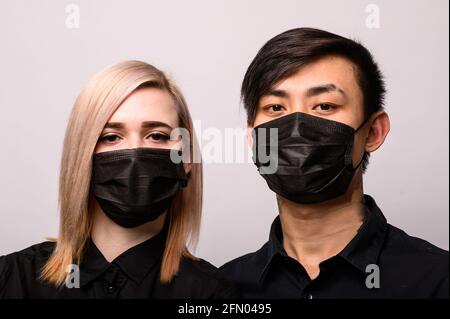 Chinesische Infektion Corona Virus maskierte Mädchen und asiatischen Mann auf dem weißen Hintergrund, das Konzept der Epidemie des Virus in China Stockfoto