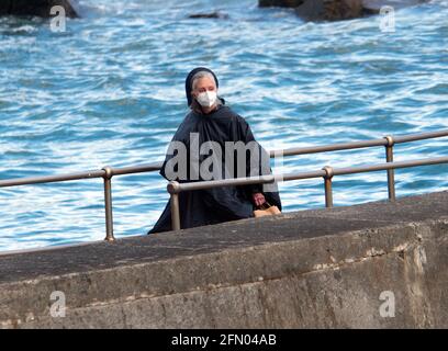 Penzance, Großbritannien. Mai 2021. Cornwall UK, St. Michaels Mount, House of Dragon. Viele der Darsteller ohne Gesichtsmasken. Die Schauspieler kehren von der Insel über eine halbe Meile offenes Meer zurück, eingewickelt in wasserfeste Umhänge, um die teuren Kostüme zu schützen. Eine raue Bootsfahrt von den Dreharbeiten auf der Insel St. Michaels Mount bis zur Hafenmauer von Marazion. April 2021. Kredit: Robert Taylor/Alamy Live Nachrichten Stockfoto