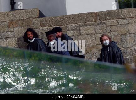 Penzance, Großbritannien. Mai 2021. Cornwall UK, St. Michaels Mount, House of Dragon. Viele der Darsteller ohne Gesichtsmasken. Die Schauspieler kehren von der Insel über eine halbe Meile offenes Meer zurück, eingewickelt in wasserfeste Umhänge, um die teuren Kostüme zu schützen. Eine raue Bootsfahrt von den Dreharbeiten auf der Insel St. Michaels Mount bis zur Hafenmauer von Marazion. April 2021. Kredit: Robert Taylor/Alamy Live Nachrichten Stockfoto