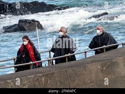 Penzance, Großbritannien. Mai 2021. Cornwall UK, St. Michaels Mount, House of Dragon. Viele der Darsteller ohne Gesichtsmasken. Die Schauspieler kehren von der Insel über eine halbe Meile offenes Meer zurück, eingewickelt in wasserfeste Umhänge, um die teuren Kostüme zu schützen. Eine raue Bootsfahrt von den Dreharbeiten auf der Insel St. Michaels Mount bis zur Hafenmauer von Marazion. April 2021. Kredit: Robert Taylor/Alamy Live Nachrichten Stockfoto