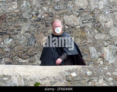 Penzance, Großbritannien. Mai 2021. Cornwall UK, St. Michaels Mount, House of Dragon. Viele der Darsteller ohne Gesichtsmasken. Die Schauspieler kehren von der Insel über eine halbe Meile offenes Meer zurück, eingewickelt in wasserfeste Umhänge, um die teuren Kostüme zu schützen. Eine raue Bootsfahrt von den Dreharbeiten auf der Insel St. Michaels Mount bis zur Hafenmauer von Marazion. April 2021. Kredit: Robert Taylor/Alamy Live Nachrichten Stockfoto