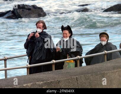 Penzance, Großbritannien. Mai 2021. Cornwall UK, St. Michaels Mount, House of Dragon. Viele der Darsteller ohne Gesichtsmasken. Die Schauspieler kehren von der Insel über eine halbe Meile offenes Meer zurück, eingewickelt in wasserfeste Umhänge, um die teuren Kostüme zu schützen. Eine raue Bootsfahrt von den Dreharbeiten auf der Insel St. Michaels Mount bis zur Hafenmauer von Marazion. April 2021. Kredit: Robert Taylor/Alamy Live Nachrichten Stockfoto