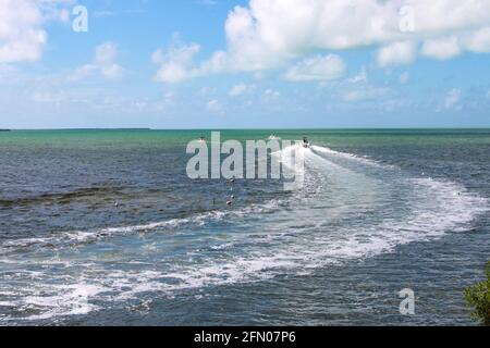 Fischerboot, das zum Horizont des Ozeans abfährt Mit geschwungener Wake Stockfoto