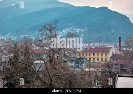 Bursa an bewölkten und regnerischen Tagen. Foto vom Bezirk tophane durch den ulu-Berg (uludag) im Hintergrund und mit pinkfarbenem Café-Restaurant Stockfoto