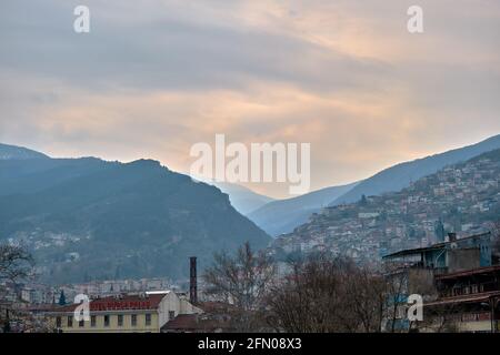 Bursa an bewölkten und regnerischen Tagen. Foto vom Bezirk tophane durch den ulu-Berg (uludag) im Hintergrund und mit pinkfarbenem Café-Restaurant Stockfoto