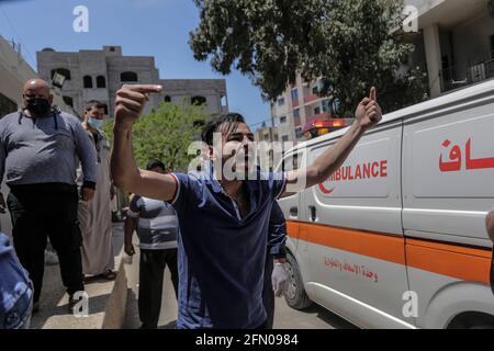 Gaza, Palästina. 12 2021. Mai: Ein Palästinenser trauert um seinen Verwandten, der während des israelischen Luftanschlags im Al-Shifa Krankenhaus getötet wurde. Die aufgrund der Spannungen um die heilige Stadt Jerusalem ausbrach, eskalierte am Mittwoch, als Israel die Tötung einer Reihe von Hamas-Führern eskalierte und die Aktivisten mit einem Sperrfeuer reagierten. Neue Raketen zielten auf Städte im Süden Israels ab. Kredit: SOPA Images Limited/Alamy Live Nachrichten Stockfoto