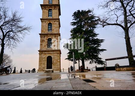 Bursa Tophane Bezirk mit altem Wachturm, der durch Ottomanen Reich errichtet wurde. Alte und alte Türme Fassade mit riesigen Wolken Hintergrund. Stockfoto