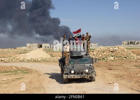 Mosul, Irak. 7. Mär 2017 Zivilisten und Soldaten fahren auf einem irakischen Spezialeinsatzgebiet Humvee in der Nähe des Bezirks Tall ar Rayyan in West Mosul. Stockfoto