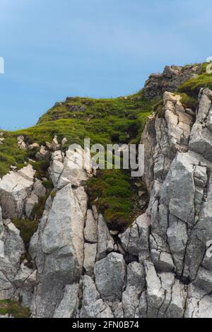 Ein blauer Himmel und grasbewachsenen Land am Rande des Berges. Mit Felsen. Stockfoto