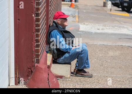 Burlington, Iowa, USA. Mai 2021. Das 1873 erbaute ehemalige Polizeidezernat in Burlington, Iowa, wird von Entwicklern eines neuen Projekts abgerissen. Ein Mann beobachtet den Abriss vom Bürgersteig. Kredit: Keith Turrill/Alamy Live Nachrichten Stockfoto