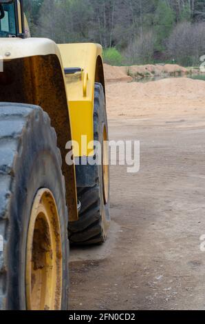 Vertikale Nahaufnahme der gelben Traktorräder Stockfoto