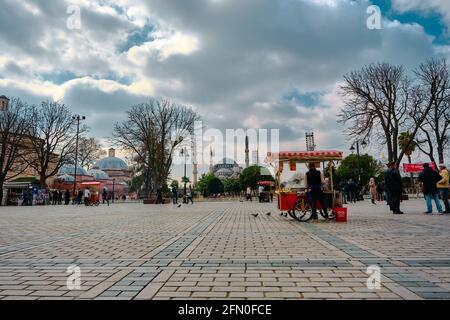 Ein Straßenverkäufer verkaufte ein Kastanien und Mais in Vorderseite der Hagia sophia Moschee in sultanahmet Platz und blau Moschee Hintergrund bei bewölktem Wetter Stockfoto