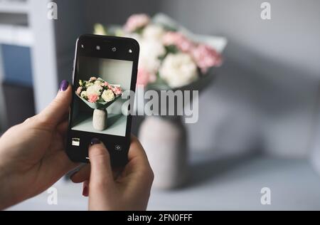 Blogger macht ein Foto von einem Blumenstrauß Stockfoto