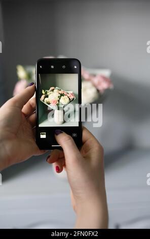 Blogger macht ein Foto von einem Blumenstrauß Stockfoto