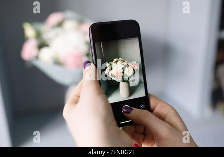 Blogger macht ein Foto von einem Blumenstrauß Stockfoto