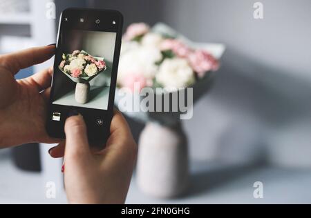 Blogger macht ein Foto von einem Blumenstrauß Stockfoto