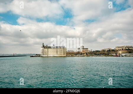 Altes barockes Gebäude des haydarpasa Hauptbahnhofs in kadikoy an der Küste istanbuls mit riesigen Wolken und türkisfarbenen bosporus-Farben. Stockfoto