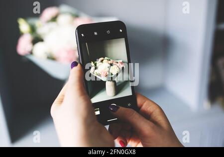 Blogger macht ein Foto von einem Blumenstrauß Stockfoto