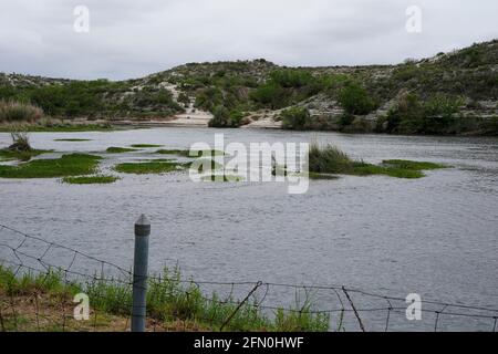 Del Rio, USA. Mai 2021. Das mit dichter Vegetation bewachsene Wanderkorsenzgebiet erstreckt sich am 12. Mai 2021 über ein hügeliges Gebiet in Mexiko entlang des Rio Grande gegenüber dem Del Rio US. Nach inoffiziellen Schätzungen sind seit Februar 2021 rund 200,000 Migranten entlang der südlichen Grenze in die Vereinigten Staaten eingedrangen. Quelle: SIPA USA/Alamy Live News Stockfoto