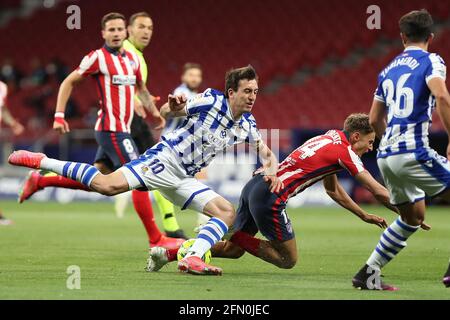 Madrid, Spanien. Mai 2021. Marcos Llorente (2. R) von Atletico steht mit Mikel Oyarzabal (3. R) von Real Sociedad während des spanischen Fußballspiels La Liga zwischen Atletico Madrid und Real Sociedad am 12. Mai 2021 in Madrid, Spanien. Quelle: Edward F. Peters/Xinhua/Alamy Live News Stockfoto