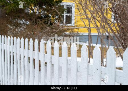 Ein weißes Holzdenkmalhaus mit hellen und lebhaften gelben Zierleisten. Stockfoto