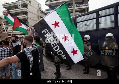 Athen, Griechenland. Mai 2021. Demonstranten halten während der Demonstration Flaggen fest und rufen Slogans. Palästinensische Demonstranten veranstalten vor der israelischen Botschaft in Athen, Griechenland, Demonstrationen gegen die Angriffe israelischer Streitkräfte auf die Al-Aqsa Moschee und den Gazastreifen. Hunderte von Demonstranten versammelten sich auf Aufruf verschiedener linker Gruppen, das palästinensische Volk zu unterstützen. Die griechische Polizei setzte Tränengas und Betäubungsgranaten gegen die Demonstranten ein, um die Demonstration zu stoppen. Kredit: SOPA Images Limited/Alamy Live Nachrichten Stockfoto