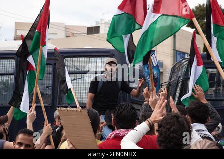 Athen, Griechenland. Mai 2021. Demonstranten halten während der Demonstration Flaggen fest und rufen Slogans. Palästinensische Demonstranten veranstalten vor der israelischen Botschaft in Athen, Griechenland, Demonstrationen gegen die Angriffe israelischer Streitkräfte auf die Al-Aqsa Moschee und den Gazastreifen. Hunderte von Demonstranten versammelten sich auf Aufruf verschiedener linker Gruppen, das palästinensische Volk zu unterstützen. Die griechische Polizei setzte Tränengas und Betäubungsgranaten gegen die Demonstranten ein, um die Demonstration zu stoppen. Kredit: SOPA Images Limited/Alamy Live Nachrichten Stockfoto