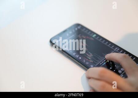 Weibliche hand mit Smartphone Handel Börse online im Coffee Shop, Business Konzept Stockfoto