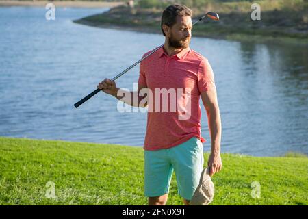 Männlicher Golfspieler auf einem professionellen Golfplatz. Porträt eines Golfspielers mit Golfschläger. Stockfoto