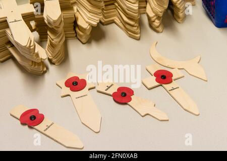 Mohnblumen auf Holzsymbolen für verschiedene religiöse Konfessionen, hergestellt in der Mohn-Fabrik der Royal British Legion, 20 Petersham Road, Richmond, London, Großbritannien. Die Poppy Factory beschäftigt Ex-Service-Mitarbeiter, die Mohnblumen, Erinnerungskreuze, Sprays und Kränze für den jährlichen Appell- und Gedenktag der Royal British Legion anstellen. Die Poppy Factory ist auch für die Anpflanzung und Ausrichtung des „Field of Remembrance“ in der Westminster Abbey verantwortlich. The Royal British Legion's Poppy Factory, 20 Petersham Road, London, Großbritannien. 16 Okt 2013 Stockfoto