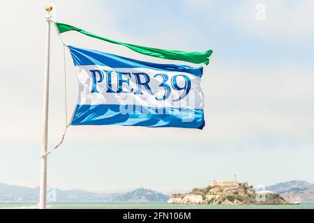 SAN FRANCISCO, CALIFORNIA, USA - 24. Juli 2018: Pier 39-Flagge auf Mast bei Fishermans Wharf, San Francisco, Westküste USA. Die Insel Alcatraz ist Stockfoto