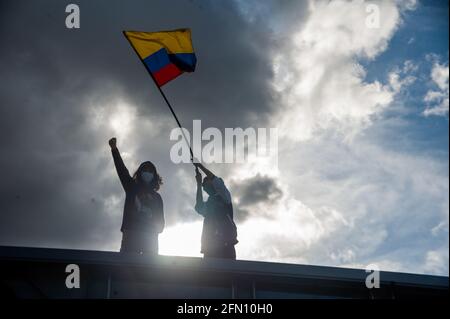 Bogota, Cundinamarca, Kolumbien. Mai 2021. Ein Demonstrator schwenkt eine kolumbianische Flagge, als Bogota, Kolumbien, seine dritte Woche regierungsfeindlicher Proteste gegen den Präsidenten Ivan Duque Marquez und die Todesfälle, die sich auf 40 Fälle von Polizeibrutalität während des Nationalstreiks am 12. Mai 2021 summieren, antritt. Kredit: Chepa Beltran/LongVisual/ZUMA Wire/Alamy Live Nachrichten Stockfoto