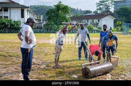 Galle, Sri Lanka - 04 17 2021: Spieler und Mitarbeiter bereiten Cricket-Feld und den Boden nach starken regen. Entfernen von überschüssigem Wasser und Schlamm, während Roller U Stockfoto