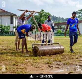 Galle, Sri Lanka - 04 17 2021: Spieler und Mitarbeiter bereiten Cricket-Feld und den Boden nach starken regen. Entfernen von überschüssigem Wasser und Schlamm, während Roller U Stockfoto