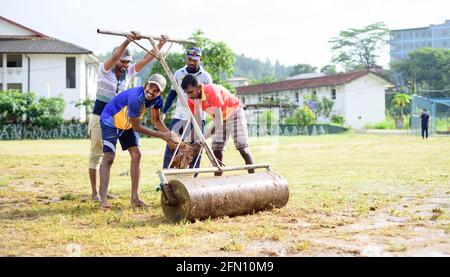 Galle, Sri Lanka - 04 17 2021: Spieler und Mitarbeiter bereiten Cricket-Feld und den Boden nach starken regen. Entfernen von überschüssigem Wasser und Schlamm, während Roller U Stockfoto