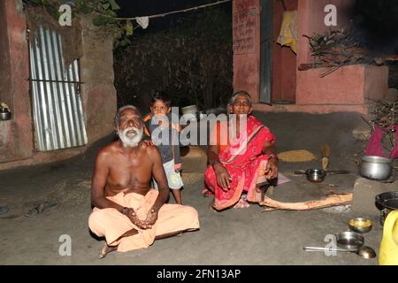 Stammes altes Paar, das mit ihrem Enkel vor ihrem Haus sitzt. BAIGA-STAMM, Chiyapadar Baiga Dorf von Odisha, Indien Stockfoto