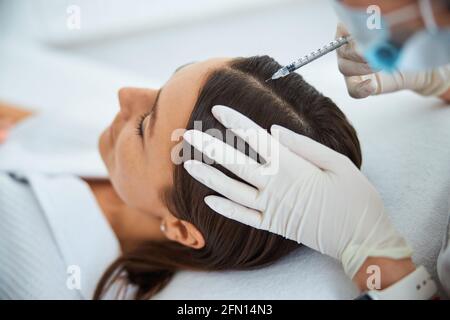 Junge Frau erhält die Serum-Kopfhautinjektion Stockfoto