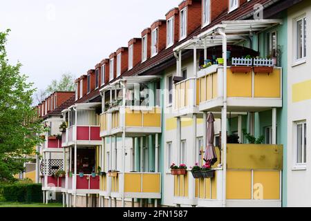 Oranienburg, Deutschland. Mai 2021. Die hintere façade eines Mehrfamilienhauses mit Balkonen der Oranienburger Wohnungsbaugenossenschaft (OWG) z.B. in der Weißen Stadt Theodor-Neubaur-Straße/Ecke Walther-Bothe-Straße ist in mehreren Farben gestaltet. Quelle: Soeren Stache/dpa-zentralbild/ZB/dpa/Alamy Live News Stockfoto