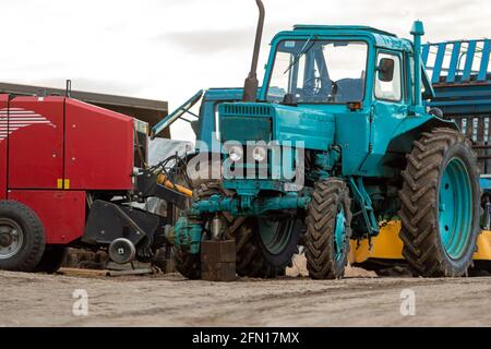 Gulbene, Lettland - 01. Mai 2021: Vintage, blau, gebrochene Belarus Traktor auf dem Hof Stockfoto