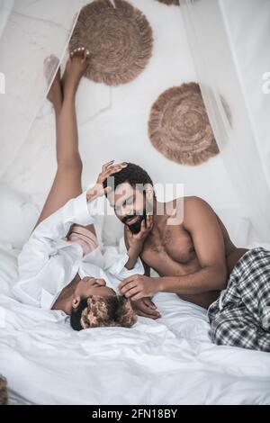 Die afrikanerin berührt sanft den Kopf ihres Mannes Stockfoto