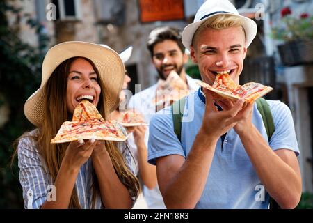 Paar essen Pizza während der Fahrt in den Urlaub Stockfoto
