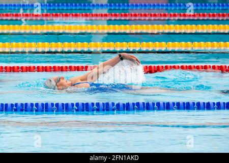 Hannover, Deutschland. Mai 2021. Eine Frau schwimmt in einem Pool des Außenpools Lister Bad. Hannover eröffnet ab heute, Donnerstag (13.05.2021), die Freibadsaison. Bei der Corona-Pandemie gelten jedoch besondere Regeln: Allein, zu zweit oder mit Personen aus dem eigenen Haushalt können Schwimmer für eine Stunde eine 50-Meter-Bahn, ein halbes Nichtschwimmerbecken oder ein halbes Tauchbecken mieten. Nur vier der acht Bahnen in den 50-Meter-Becken werden gleichzeitig vermietet - um die Abstandsregeln einhalten zu können. Quelle: Moritz Frankenberg/dpa/Alamy Live News Stockfoto