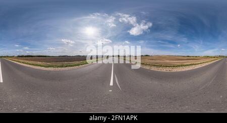 Vollständiges, kugelförmiges, nahtloses Panorama 360 Grad-Ansicht bei No Verkehr alte Asphaltstraße zwischen Feldern mit klarem Himmel und Weiße Wolken in gleicheckig Stockfoto