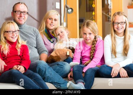 Familie mit Mutter, Vater und Kinder bequem auf Sofa sitzen Stockfoto
