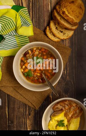 Linsen-, Bohnen- und Kichererbsen-Suppe mit Sodabrot und Backkartoffeln Stockfoto