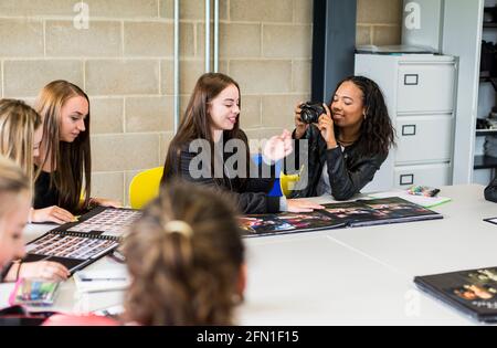 Multikulturelle Studenten der sechsten Klasse, junge Menschen in der Bildung, Gruppe junger Studentinnen in der sechsten Klasse, Studenten, die in der Fotoklasse interagieren Stockfoto