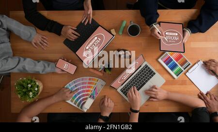 Overhead-Aufnahme des Briefings des Designer-Teams über ihr Projekt mit Digitale Geräte und Designer-Zubehör nachmachen Stockfoto