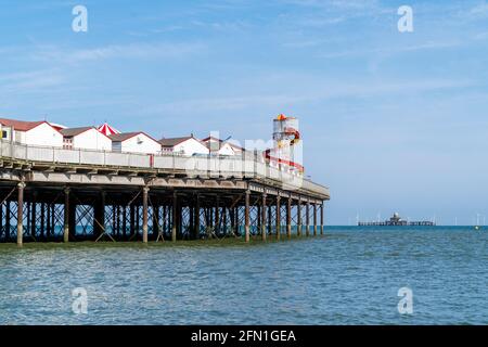 Der Pier von Herne Bay mit den Überresten des Piers liegt eine Meile entfernt im Meer und die Turbinen des Offshore-Windparks Kentish Flats am Horizont. Stockfoto