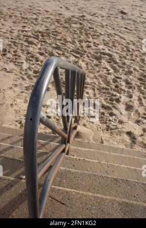 Vertikales Fallbild eines dekorativen Metallhandlaufs nach unten Zum Strand Stockfoto