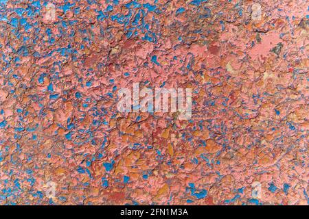 Die Farbe blätterte von der Wand ab. Betonwand. Verwitterte raue lackierte Oberfläche mit Rissmustern und Delaminierung. Hohe Qualität Stockfoto